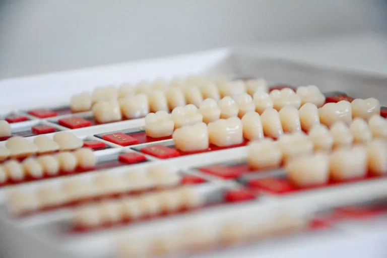 A tray of finished porcelain dental crowns at Smile! San Francisco